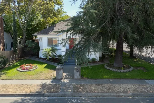 a view of backyard with wooden fence and large trees