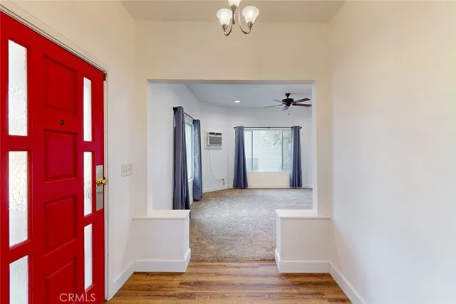 a kitchen with stainless steel appliances granite countertop a sink a stove a refrigerator with grey cabinets and wooden floor