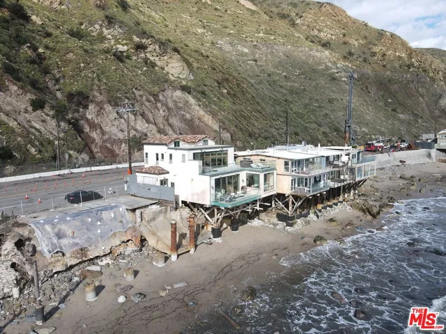 a view of residential houses with yard and mountain view in back