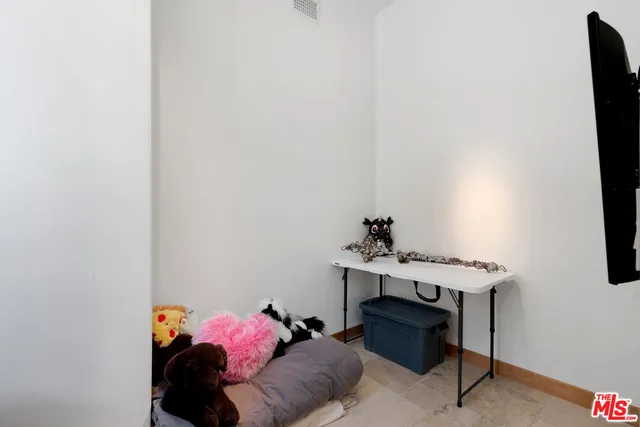 a bedroom with a bed and large windows