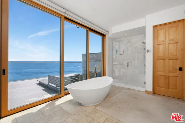 a spacious bathroom with a granite countertop sink a toilet a mirror and shower