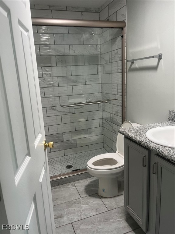 154 Village Circle LaBelle, FL 33935 - Photo 3 of 6 a bathroom with a granite countertop toilet a sink and a shower