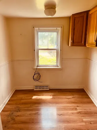 a view of a room with wooden floor and a window