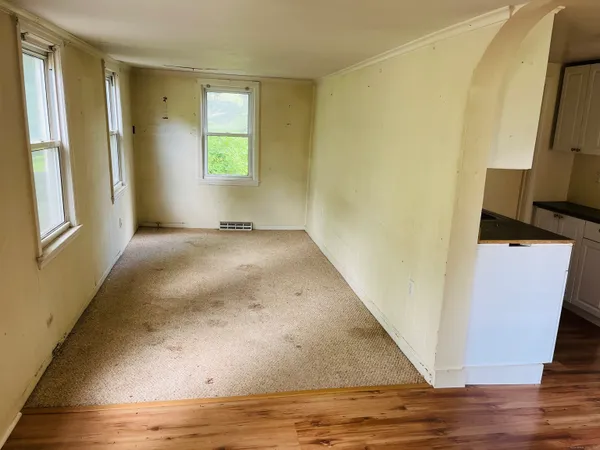 a view of an empty room with window and closet area