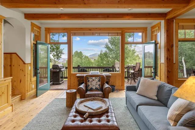 a living room with furniture and a floor to ceiling window
