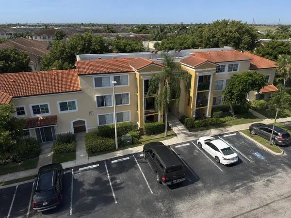 an aerial view of a house with car parked