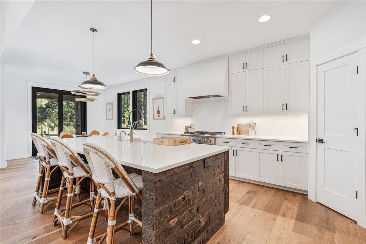 56278 Sable Rock Loop Bend, OR 97707 - Photo 12 of 54 a kitchen with center island white cabinets and stainless steel appliances