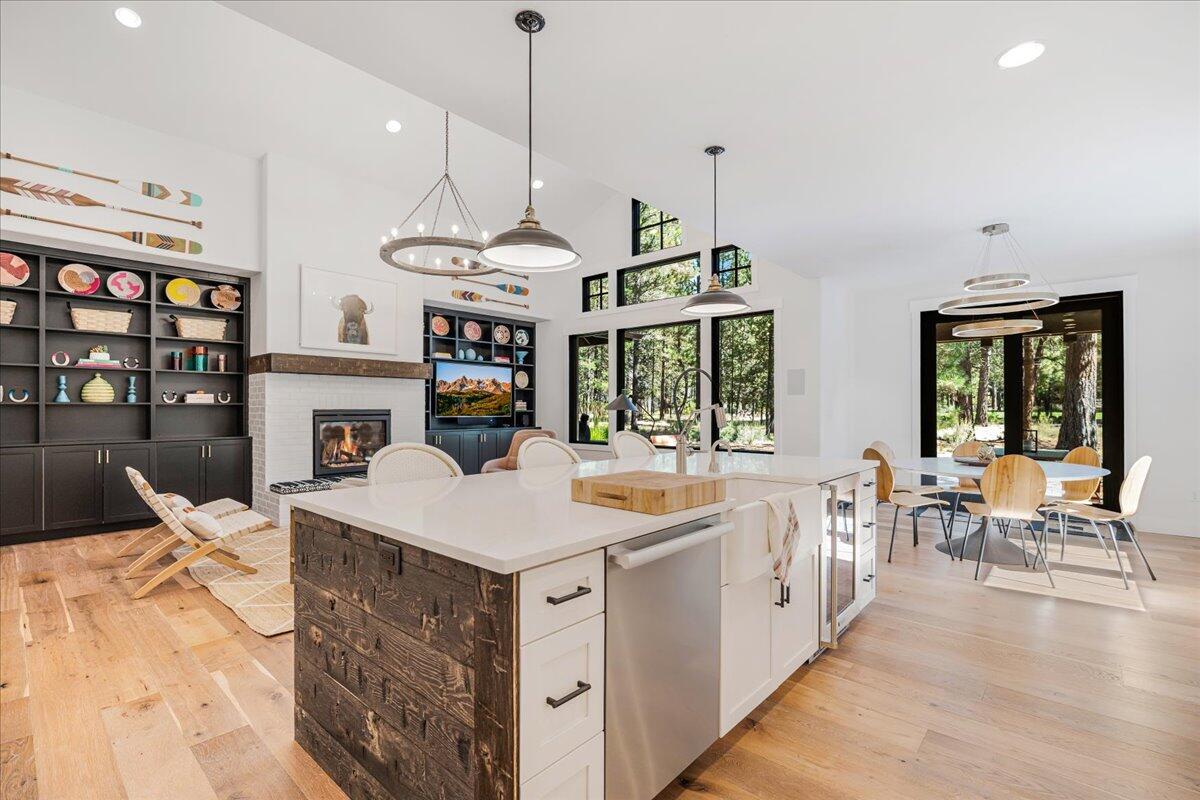 56278 Sable Rock Loop Bend, OR 97707 - Photo 13 of 54 a open kitchen with stainless steel appliances granite countertop a kitchen island a stove a sink a dining table and chairs with wooden floor