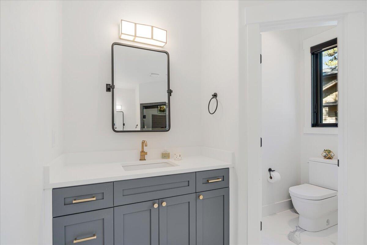 56278 Sable Rock Loop Bend, OR 97707 - Photo 22 of 54 a bathroom with a toilet sink vanity and mirror