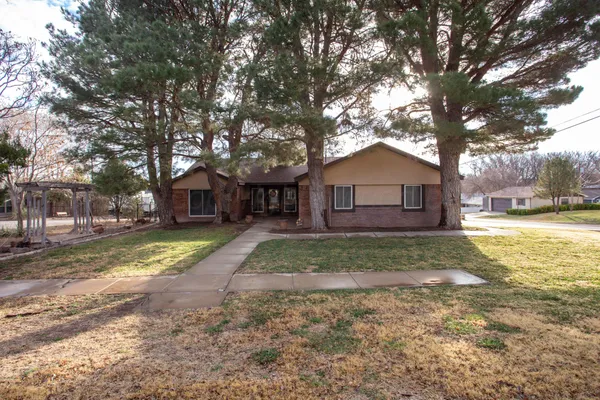 a view of a yard in front of a house with large trees