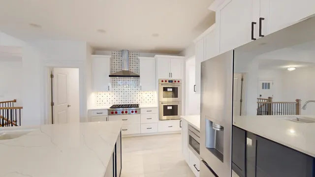a large white kitchen with stainless steel appliances