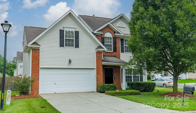 a front view of a house with a garden and plants