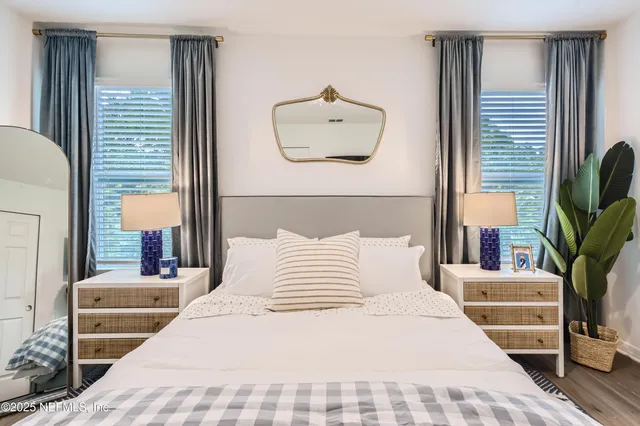 a bedroom with a large bed and a potted plant