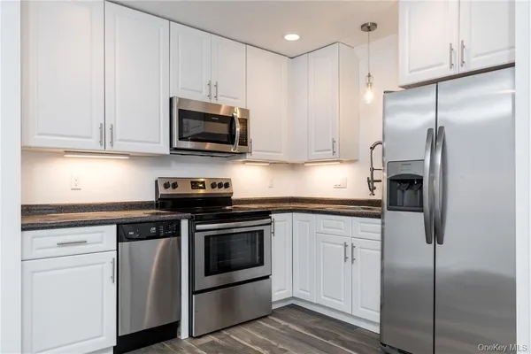 a kitchen with stainless steel appliances granite countertop a stove a refrigerator and a sink