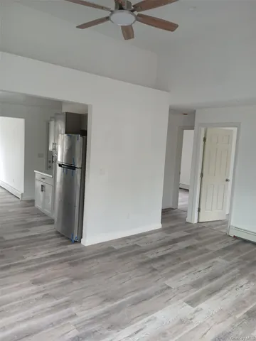 a view of a kitchen with a sink refrigerator and wooden floor