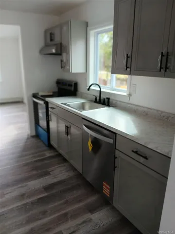 a kitchen with stainless steel appliances granite countertop a sink stove and wooden floor