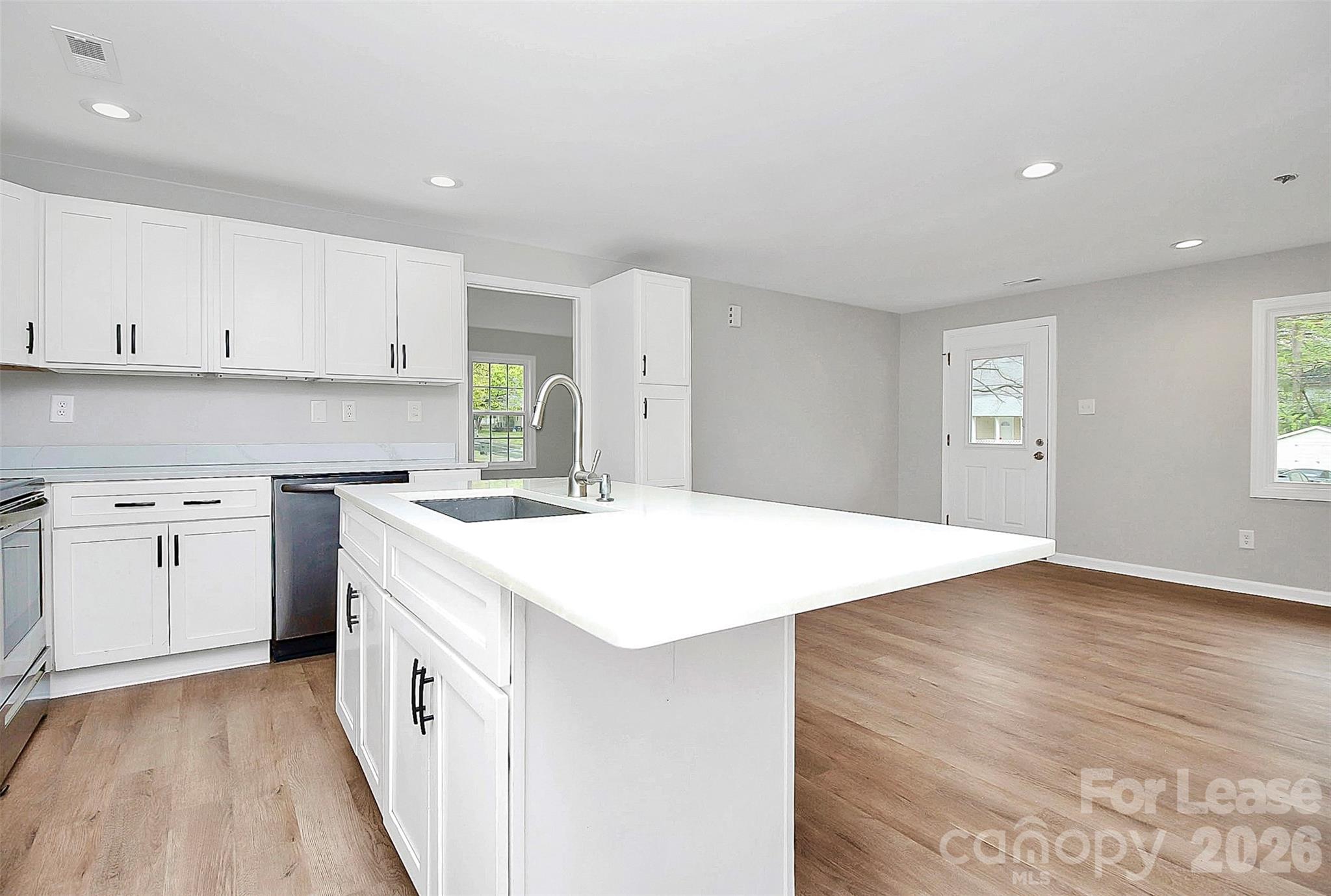 315 South Ransom Street Gastonia, NC 28052 - Photo 8 of 18 a kitchen that has a lot of white cabinets and wooden floor