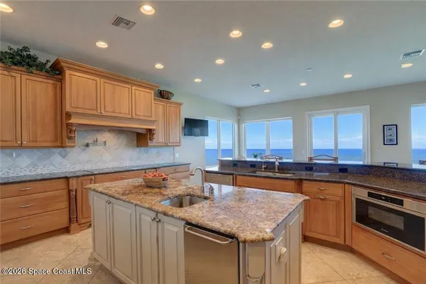 a kitchen with stainless steel appliances granite countertop a sink counter space cabinets and a stove
