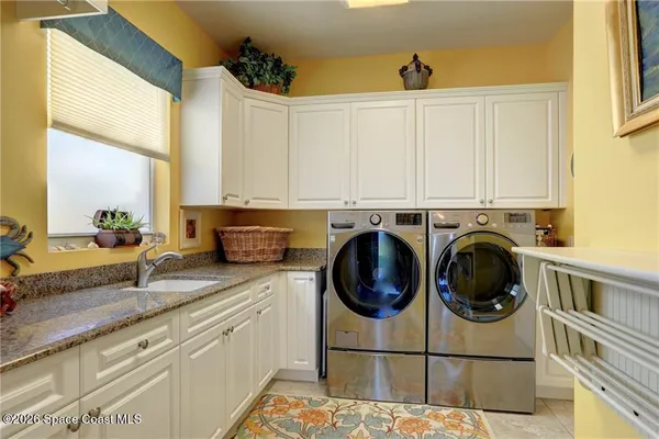 a view of a kitchen with sink washer and dryer