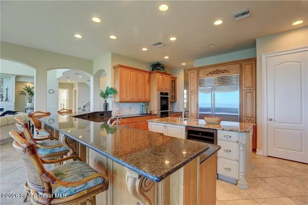 a kitchen with stainless steel appliances granite countertop a sink and a refrigerator
