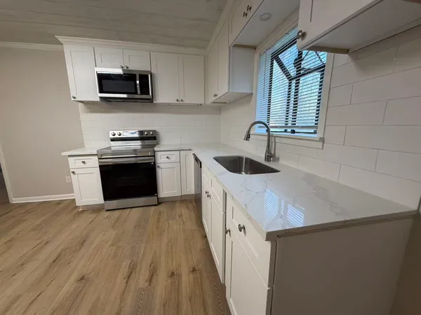 a kitchen with stainless steel appliances granite countertop a sink stove a microwave and a refrigerator