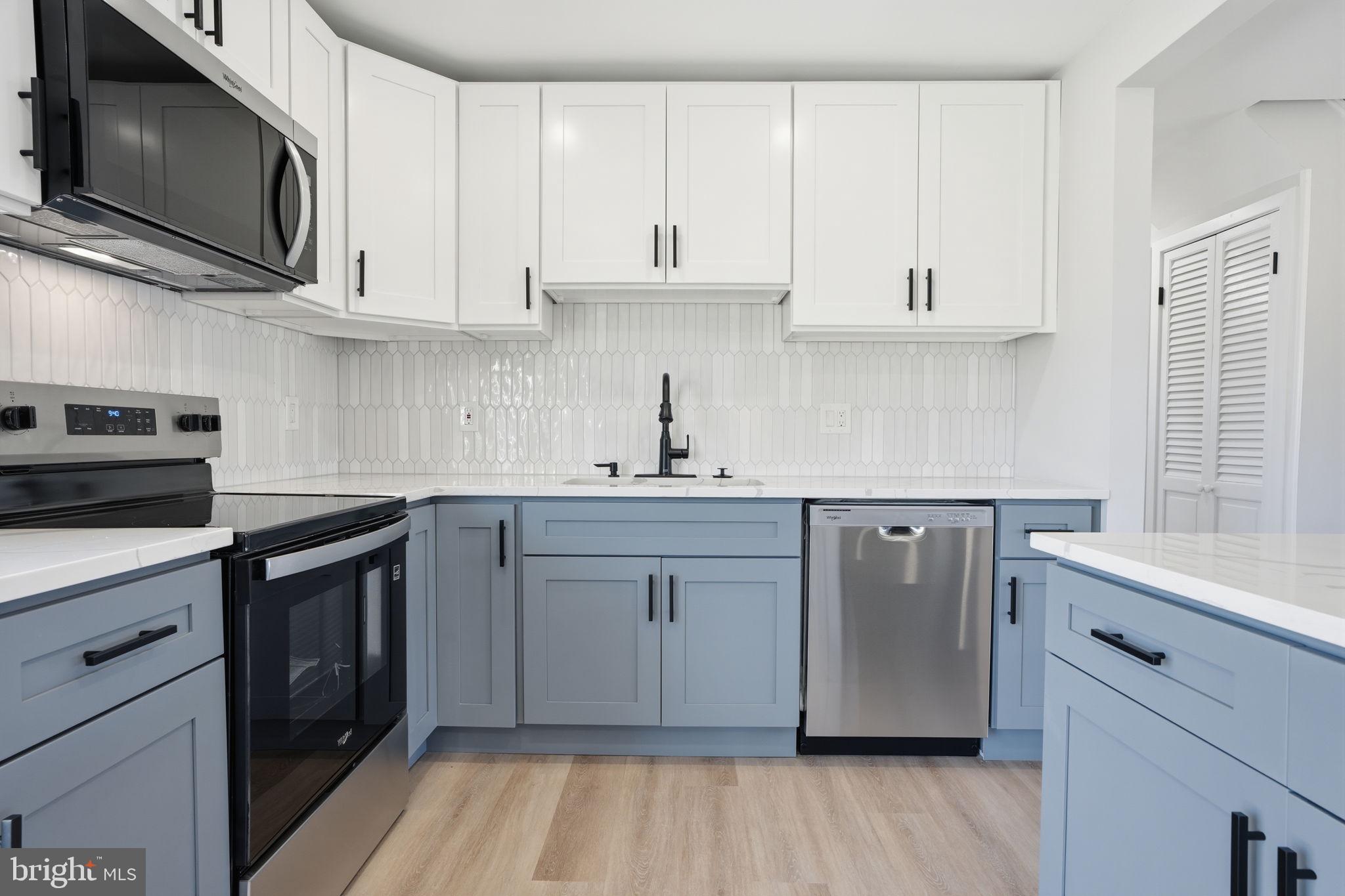 10 MacIntosh Road Levittown, PA 19056 - Photo 18 of 41 a kitchen with stainless steel appliances granite countertop a sink a stove a microwave and cabinets