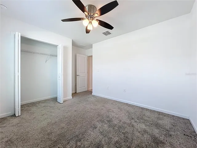 an empty room with chandelier fan