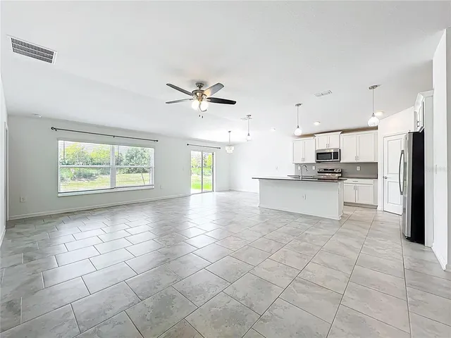 a view of kitchen with granite countertop a stove a sink and a refrigerator