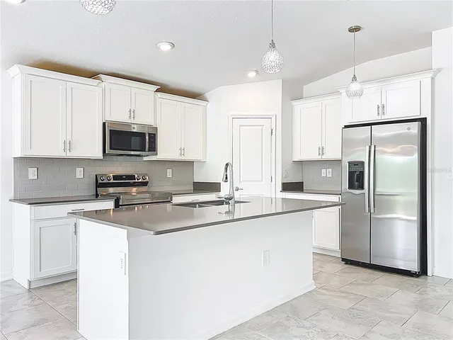 a kitchen with stainless steel appliances a refrigerator sink and microwave