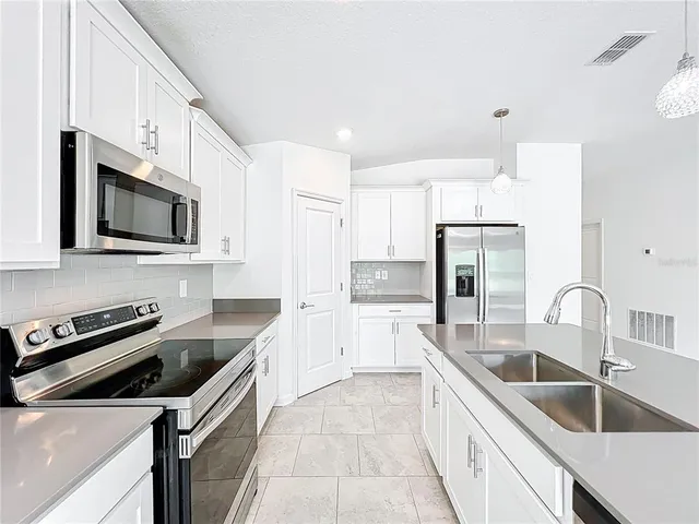 a kitchen that has a sink and a stove top oven