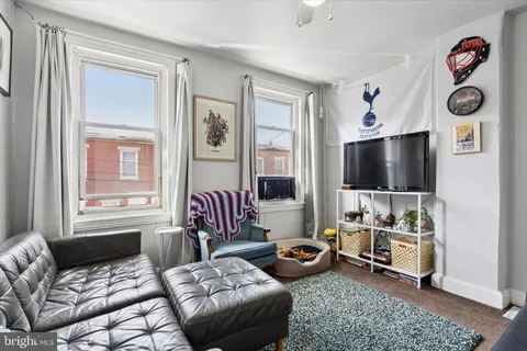 a living room with furniture a couch and dresser