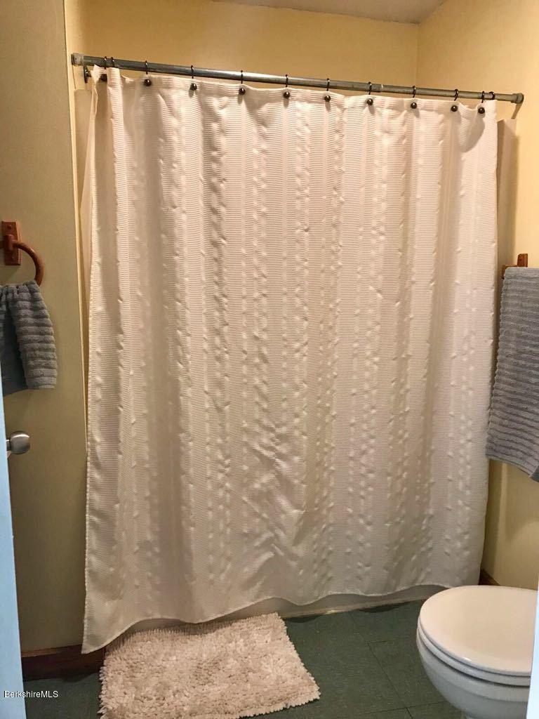 1304 Main Road Savoy, MA 01256 - Photo 7 of 28 a bathroom with a toilet and a shower curtain