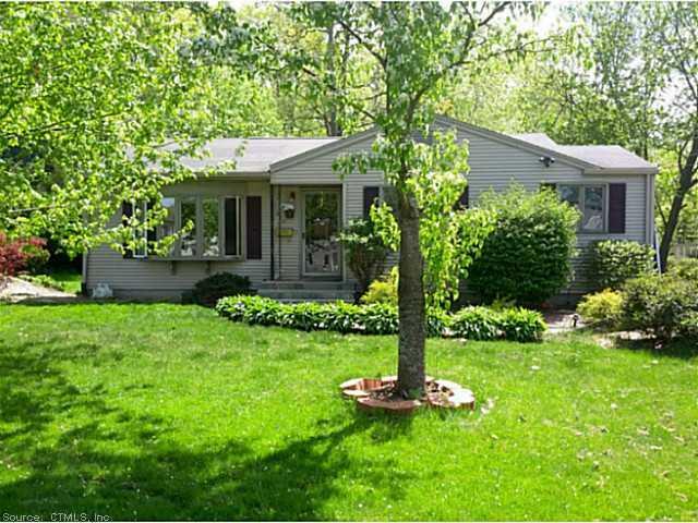 a front view of a house with a yard and a garden