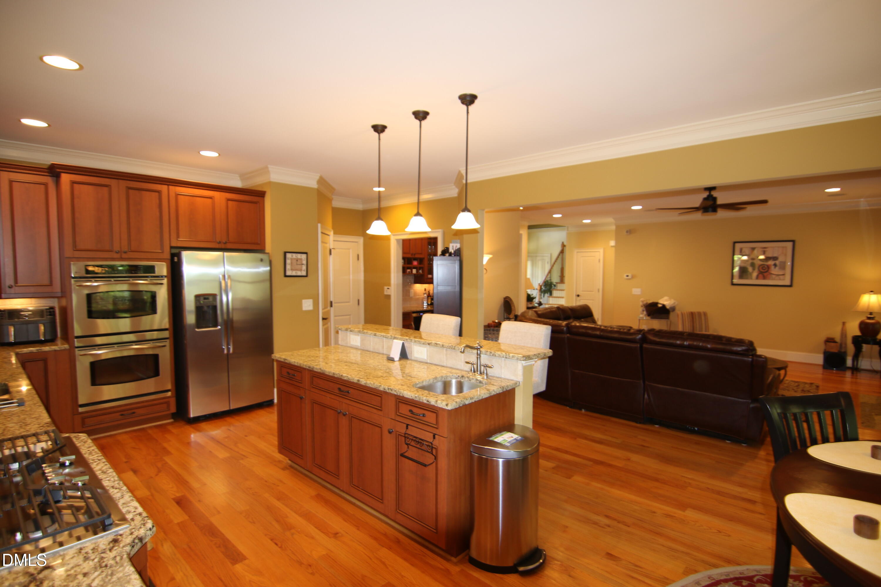 8104 Henderson Road Apex, NC 27539 - Photo 11 of 45 a kitchen with stainless steel appliances kitchen island granite countertop a refrigerator a stove top oven and a sink