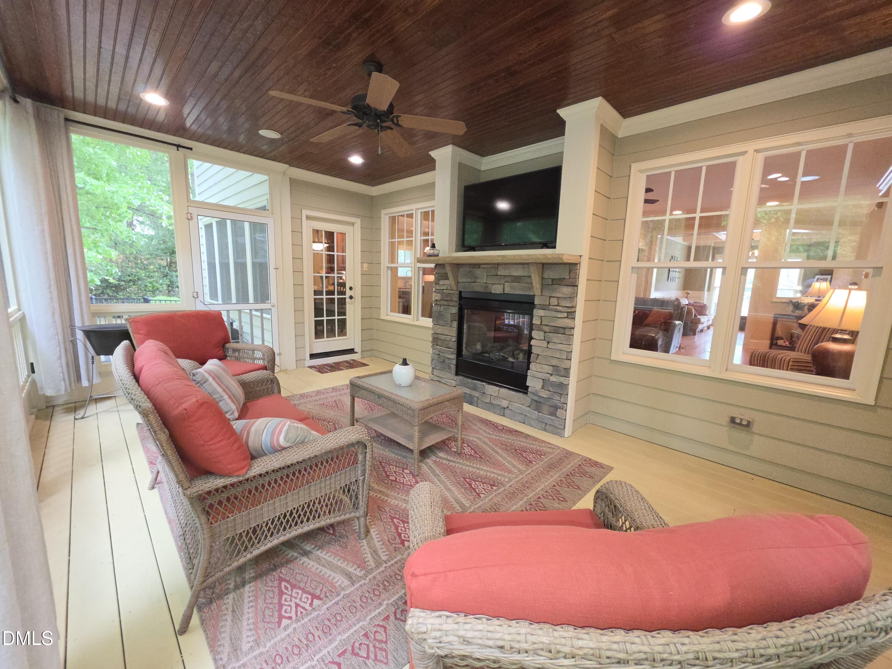 8104 Henderson Road Apex, NC 27539 - Photo 16 of 45 a living room with furniture a fireplace and floor to ceiling windows