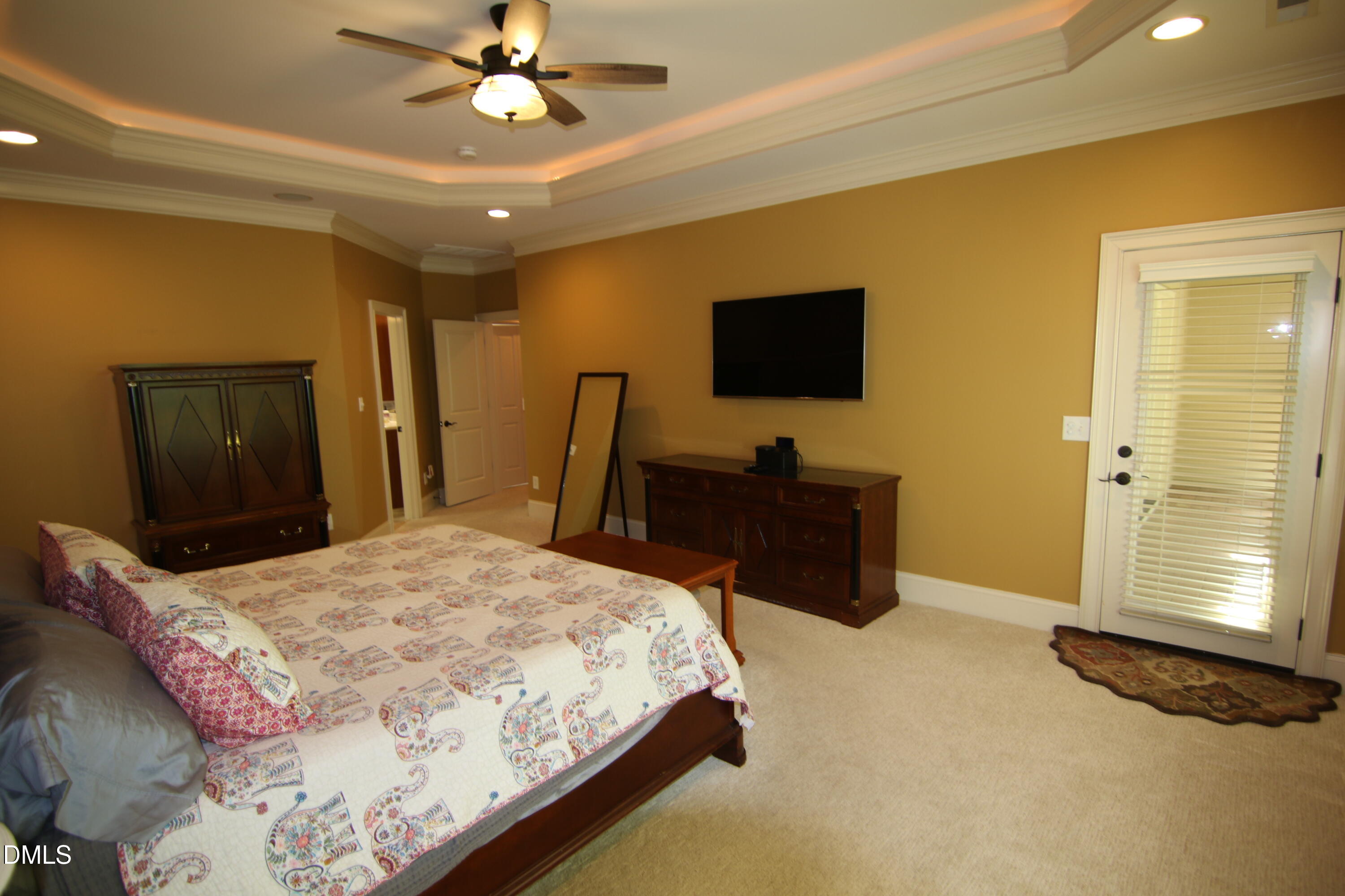 8104 Henderson Road Apex, NC 27539 - Photo 24 of 45 a bedroom with a bed and a flat screen tv