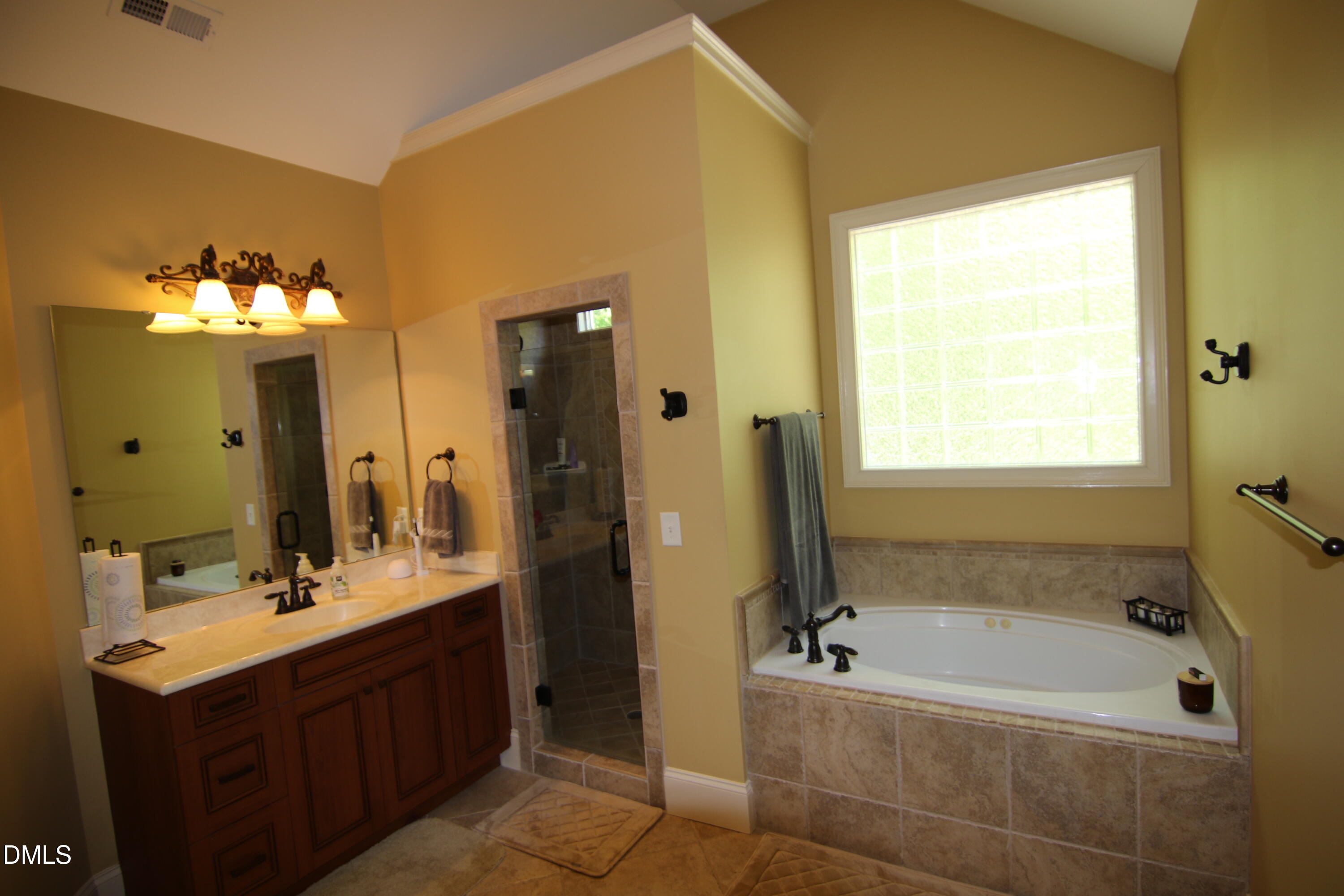 8104 Henderson Road Apex, NC 27539 - Photo 27 of 45 a bathroom with a tub sink and mirror