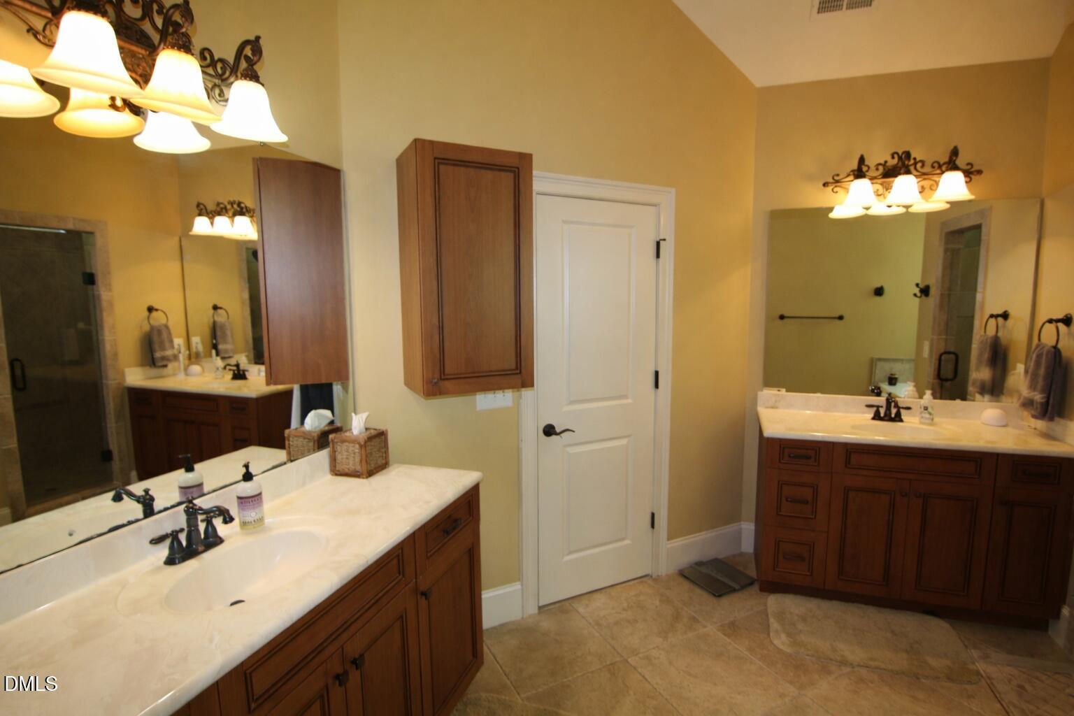 8104 Henderson Road Apex, NC 27539 - Photo 28 of 45 a bathroom with a double vanity sink and a mirror