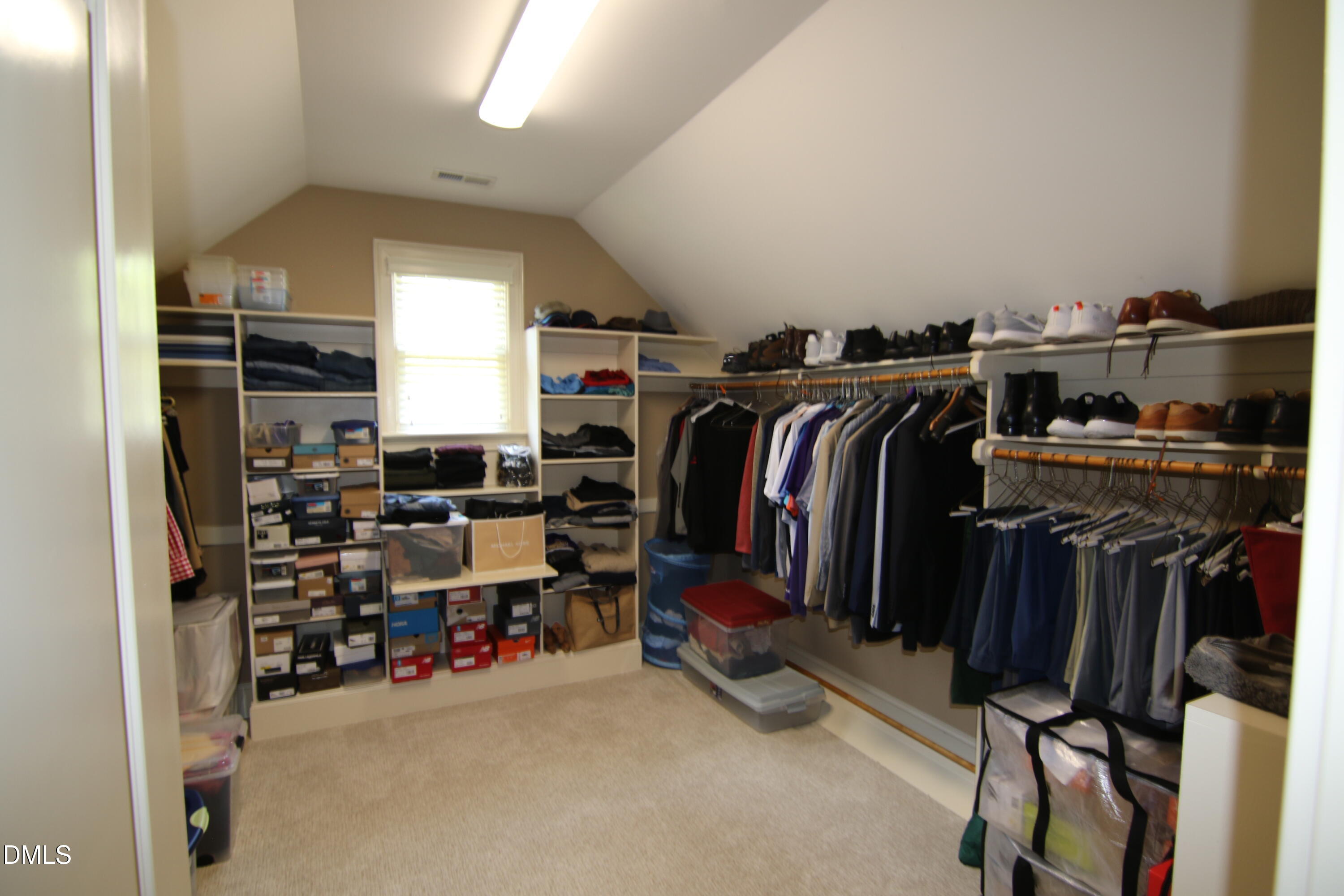 8104 Henderson Road Apex, NC 27539 - Photo 30 of 45 a view of walk in closet with clothes and shoes