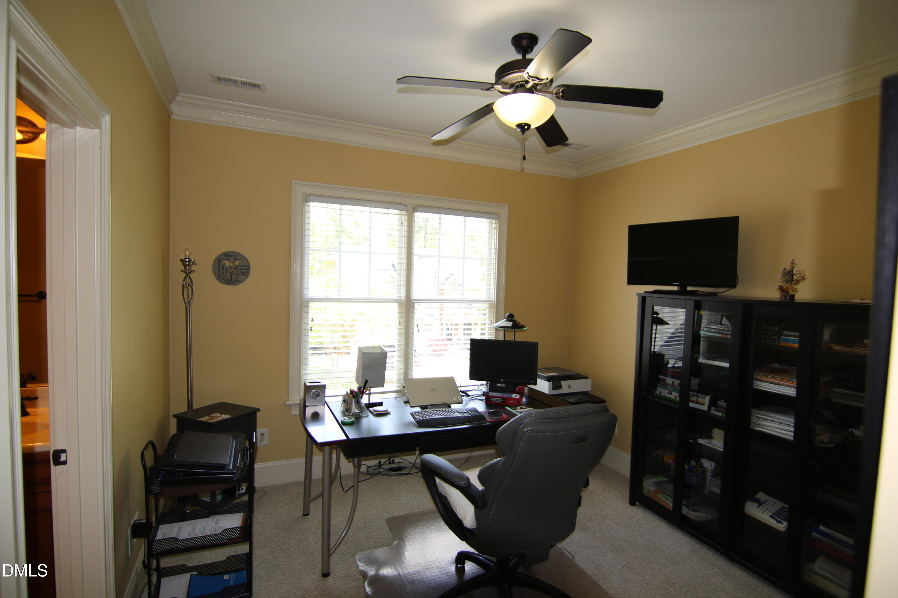 8104 Henderson Road Apex, NC 27539 - Photo 33 of 45 a work room with furniture a flat screen tv and a window