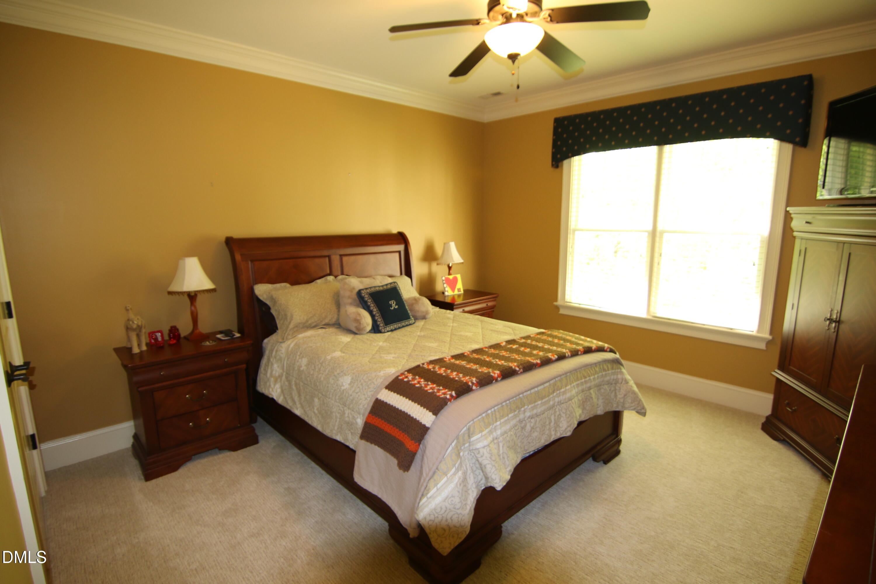 8104 Henderson Road Apex, NC 27539 - Photo 38 of 45 a spacious bedroom with a bed and a chandelier