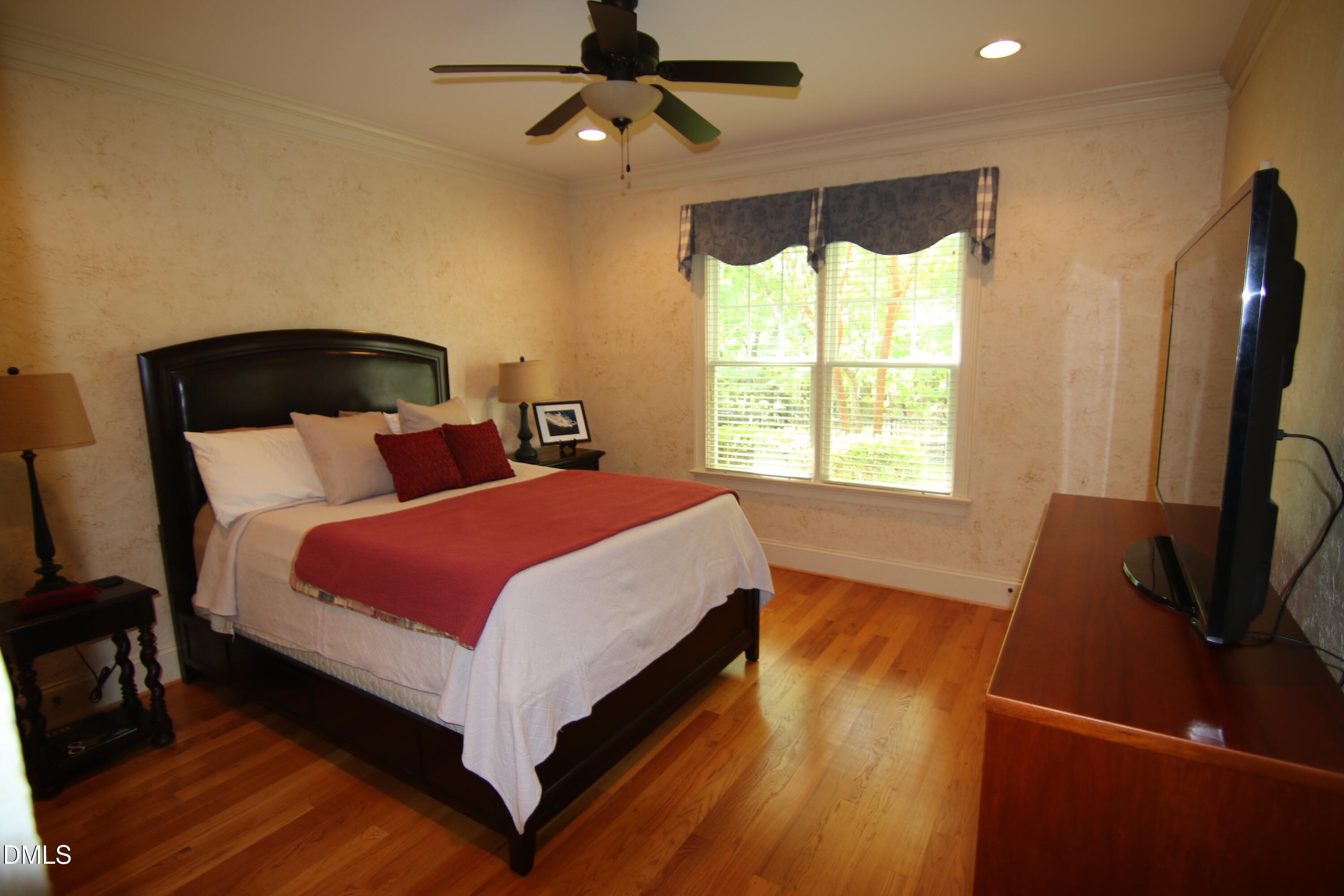 8104 Henderson Road Apex, NC 27539 - Photo 40 of 45 a bedroom with a bed window and a flat tv screen