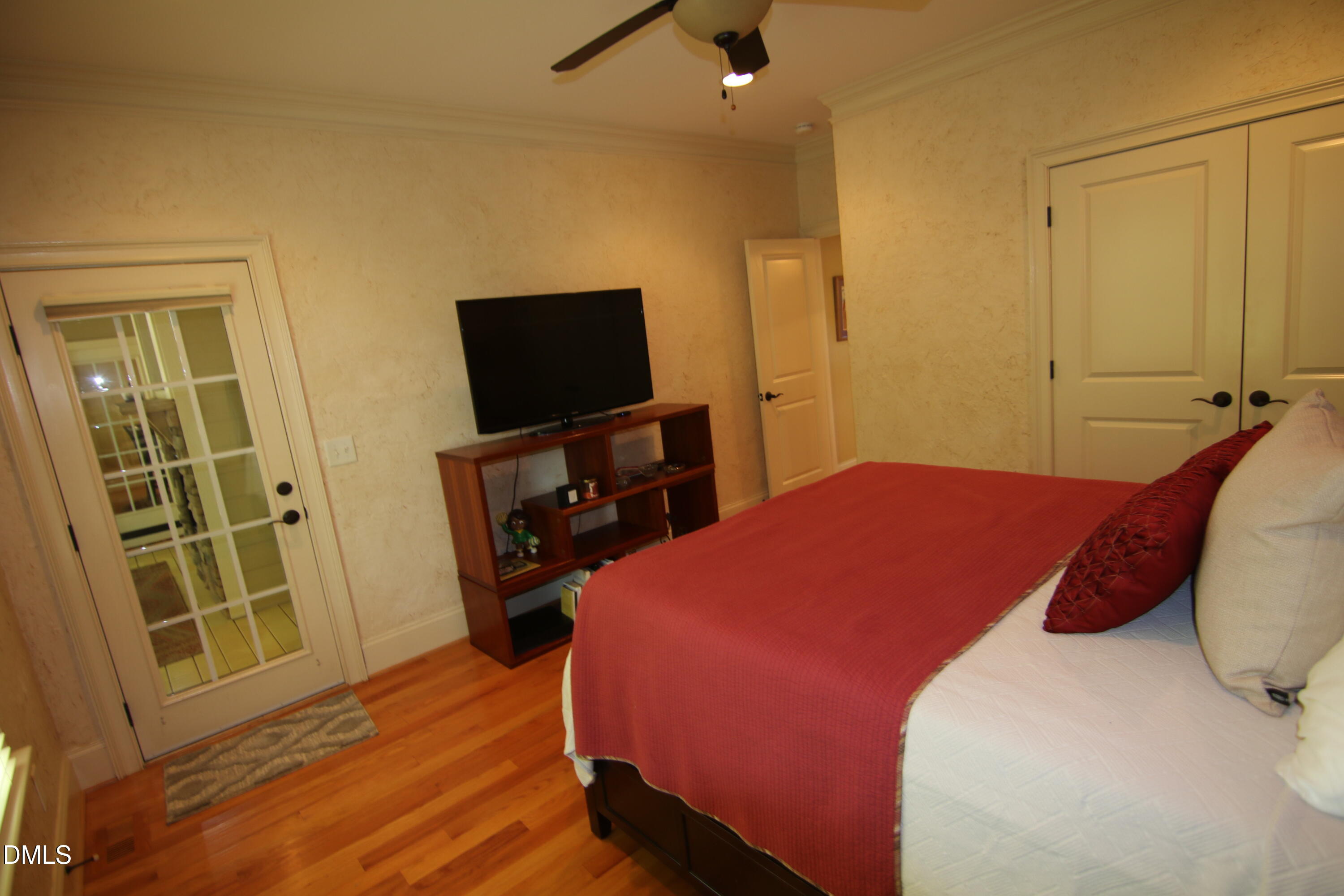 8104 Henderson Road Apex, NC 27539 - Photo 42 of 45 a bedroom with a bed and wooden floor