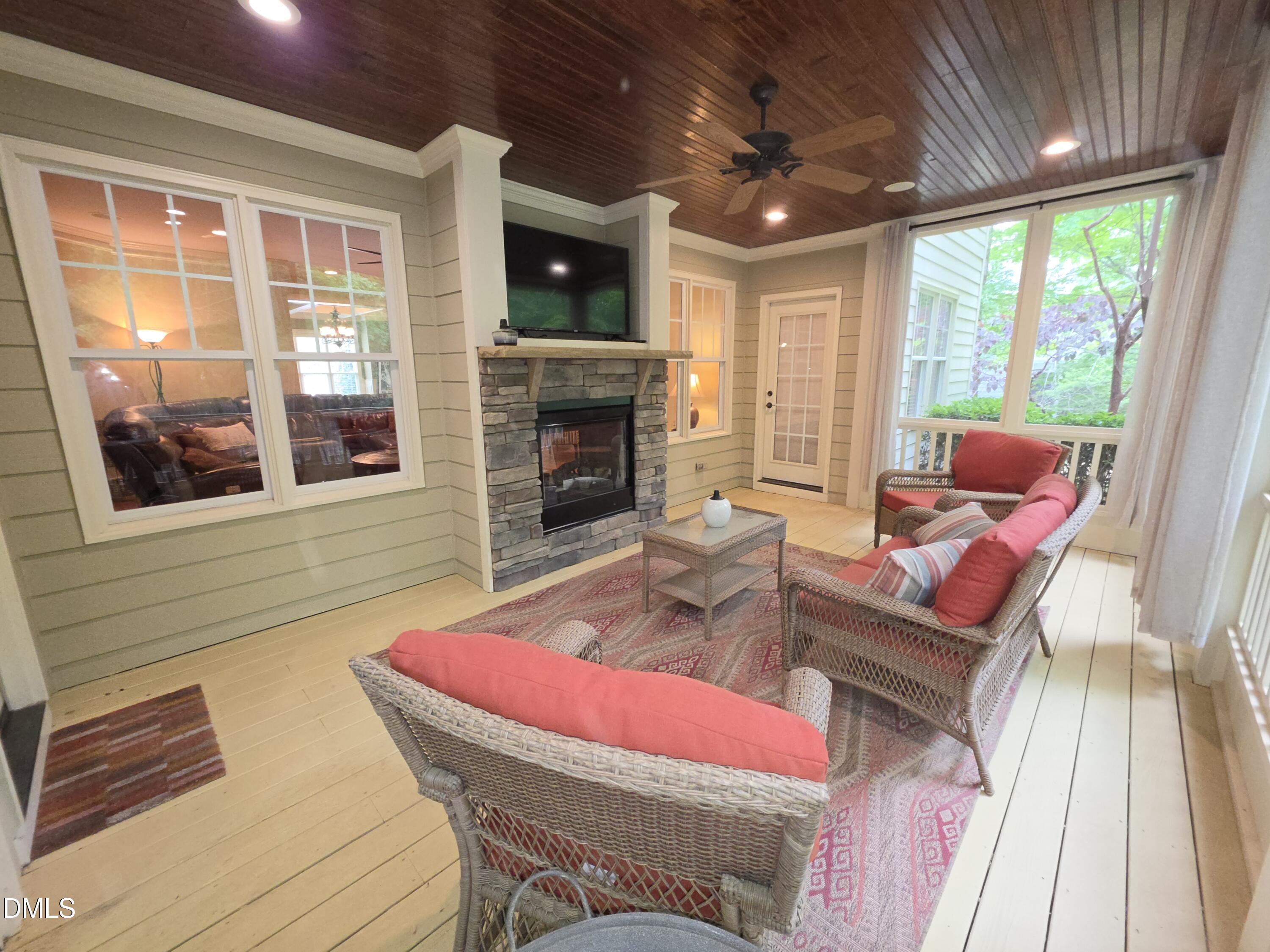 8104 Henderson Road Apex, NC 27539 - Photo 43 of 45 a living room with furniture a fireplace and a floor to ceiling window