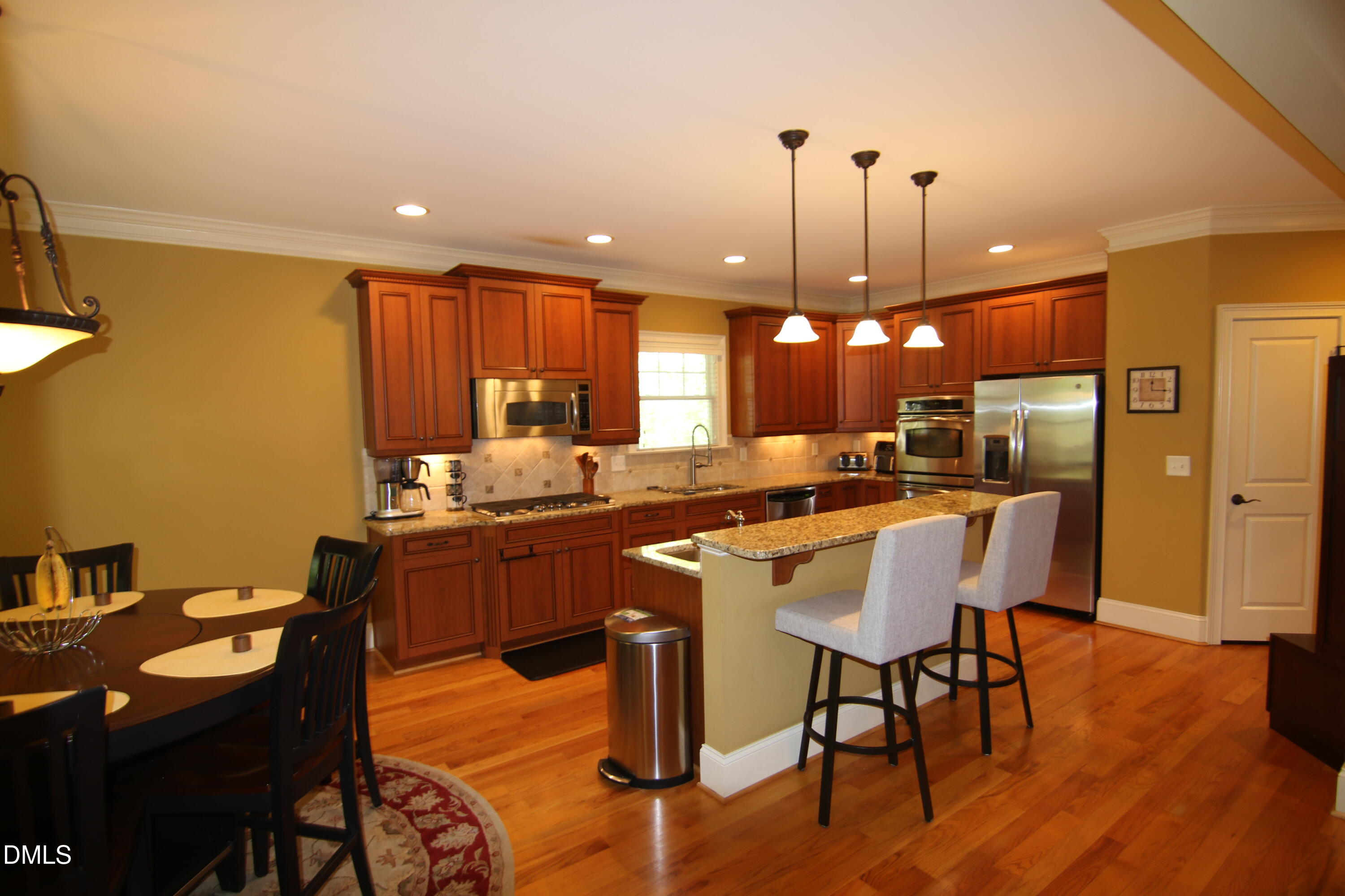 8104 Henderson Road Apex, NC 27539 - Photo 10 of 45 a kitchen with a dining table chairs and wooden floor