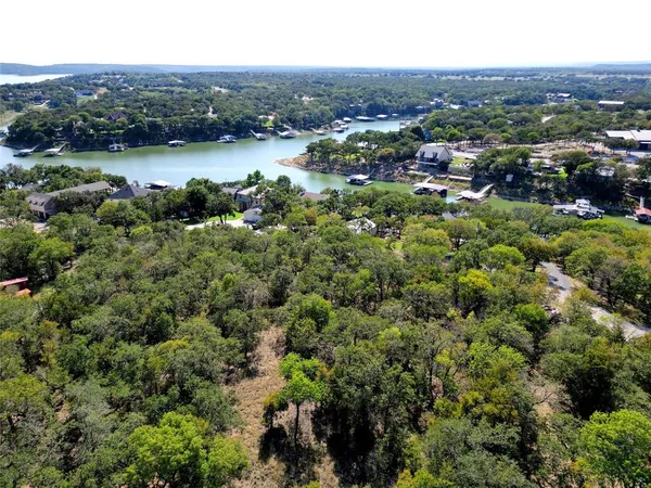 an aerial view of residential houses with outdoor space and lake view