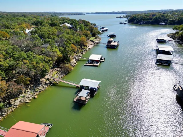 an aerial view of a house with yard lake view and boat