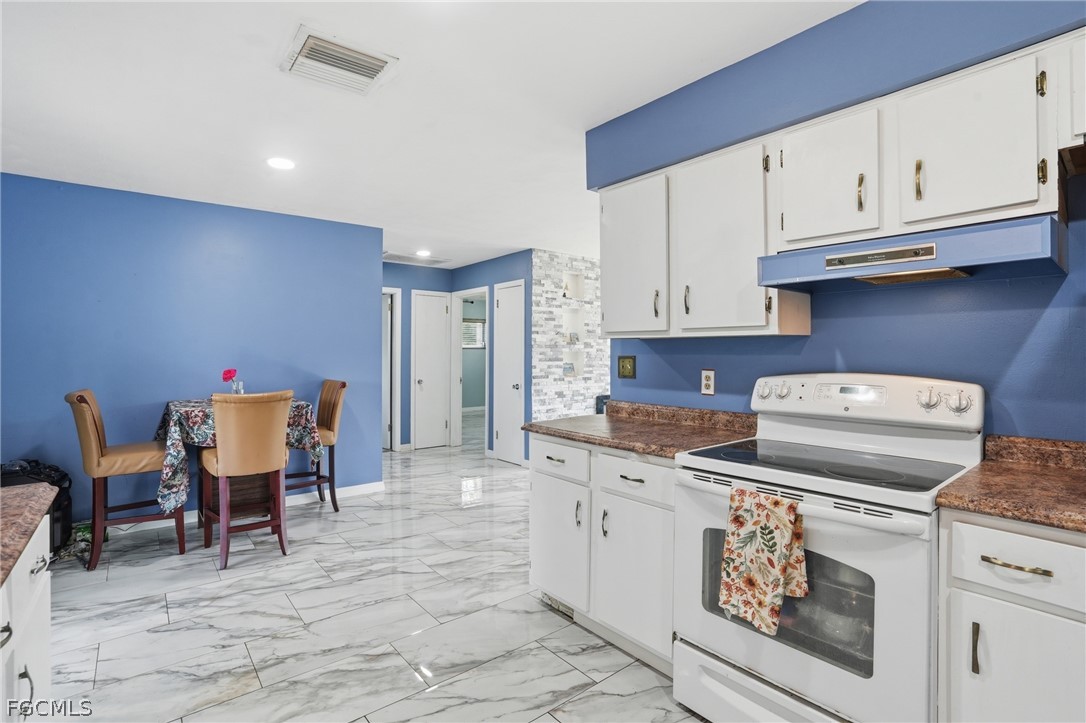 2180 Cook Lane Alva, FL 33920 - Photo 15 of 46 a kitchen with a stove and white cabinets