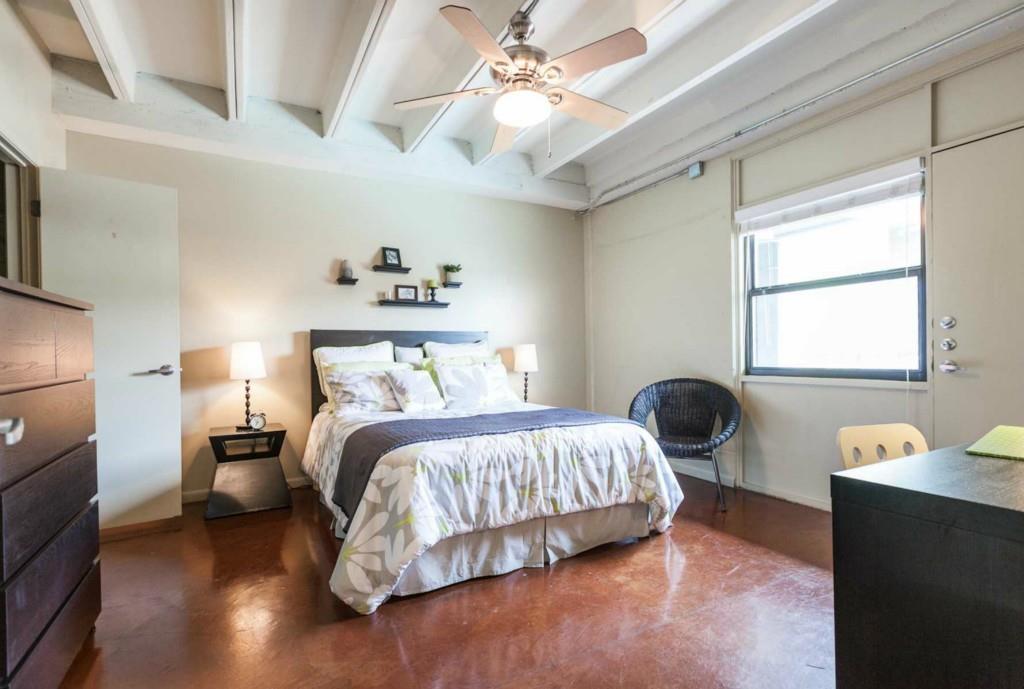 2408 Leon Street, Unit 115 Austin, TX 78705 - Photo 4 of 9 a bedroom with a bed and wooden floor