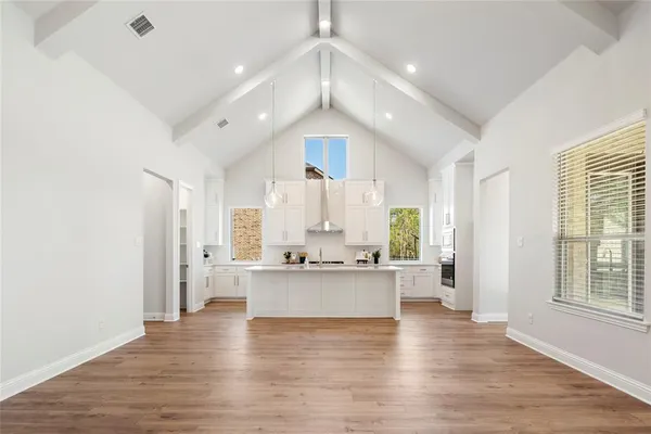 a large white kitchen with a large window and stainless steel appliances